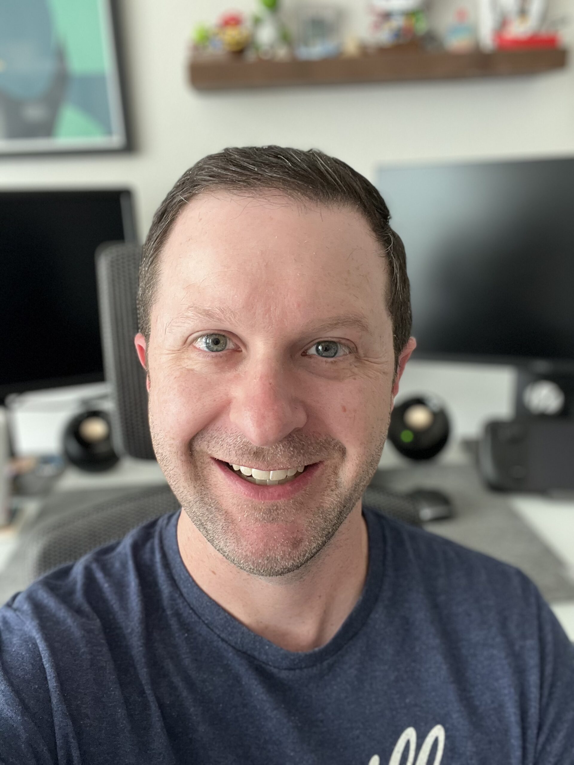 This is Chris who is the owner of the website smiling. In the background you see monitors and speakers.